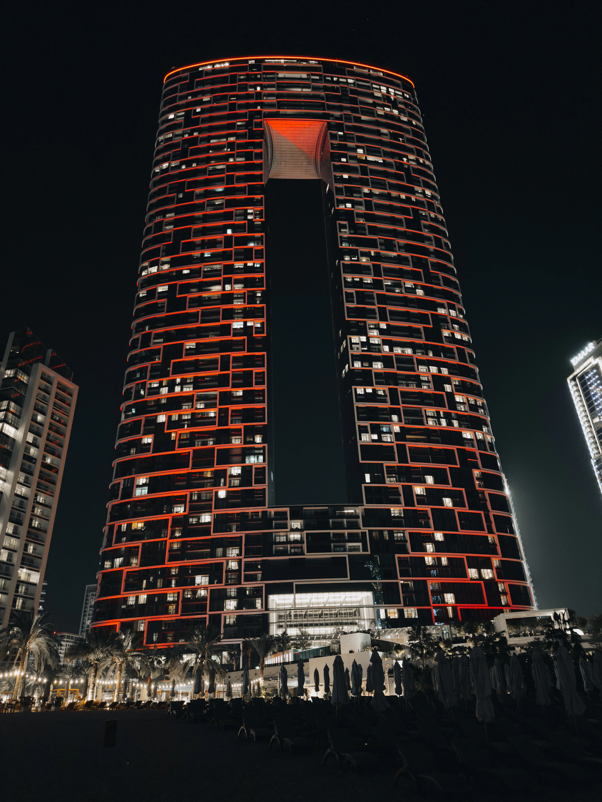A tall building lit up at night in a city