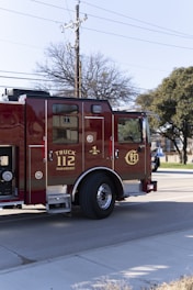 A red fire truck driving down a street