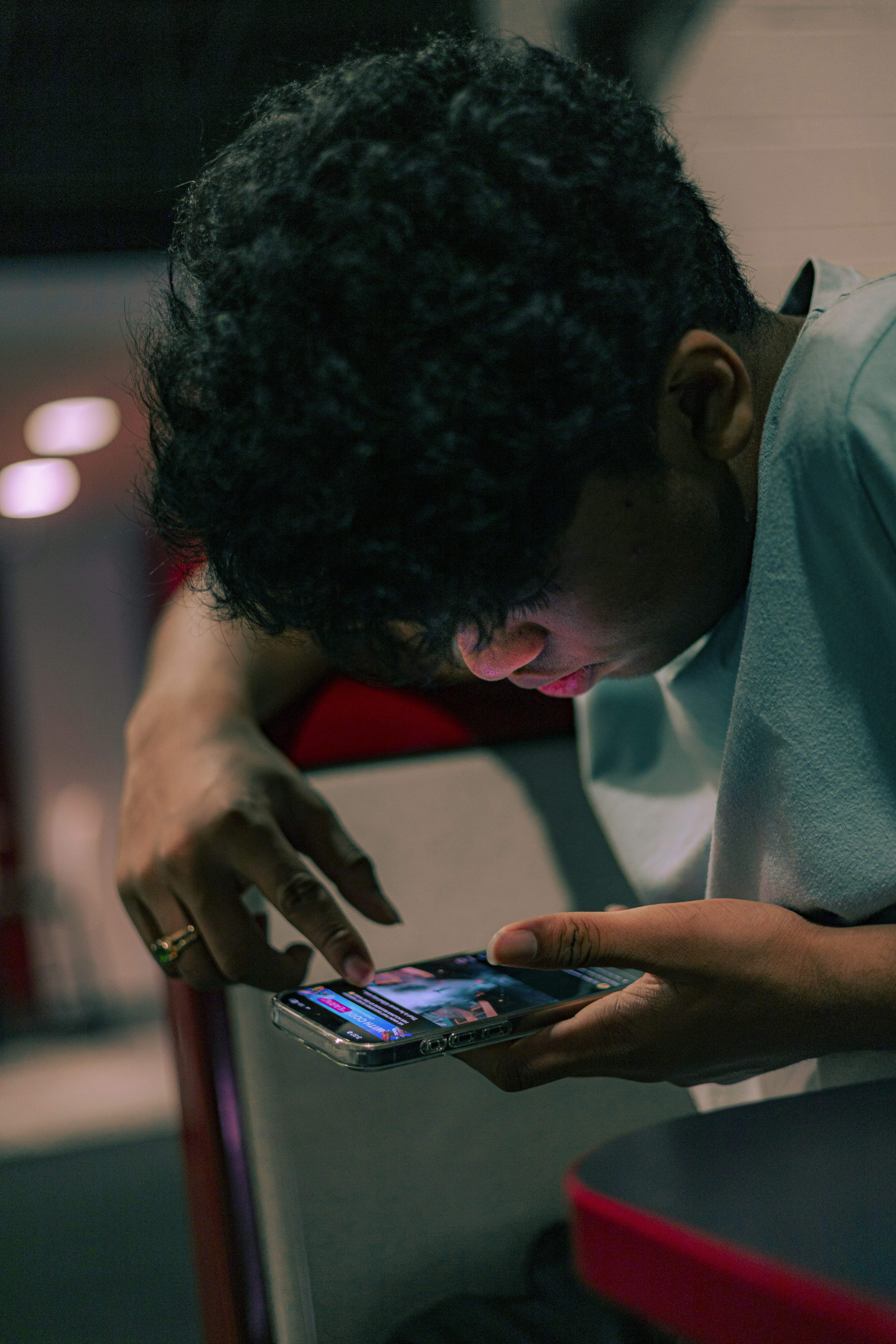 A man sitting down looking at a cell phone