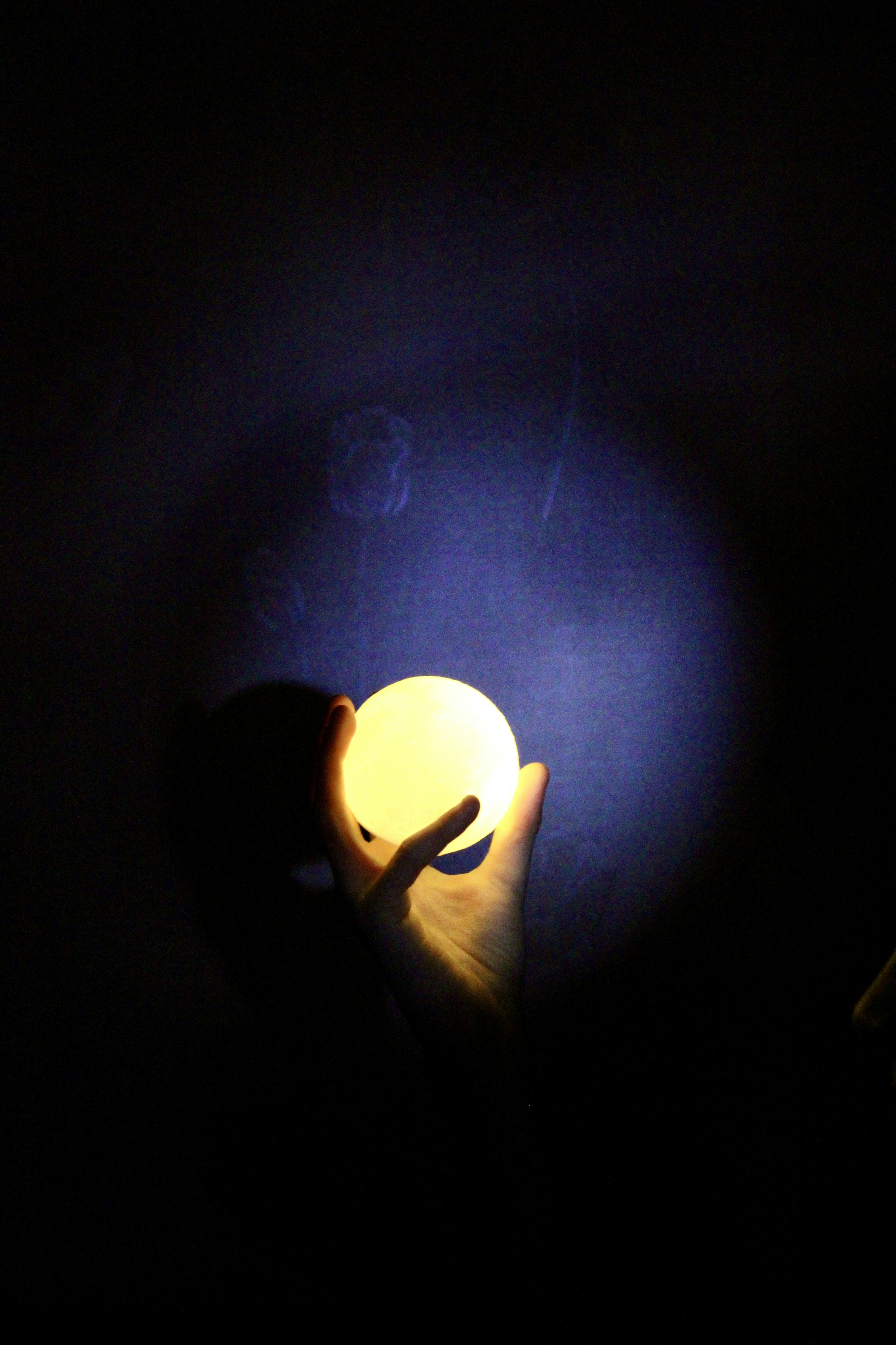 Una persona che tiene un oggetto giallo al buio