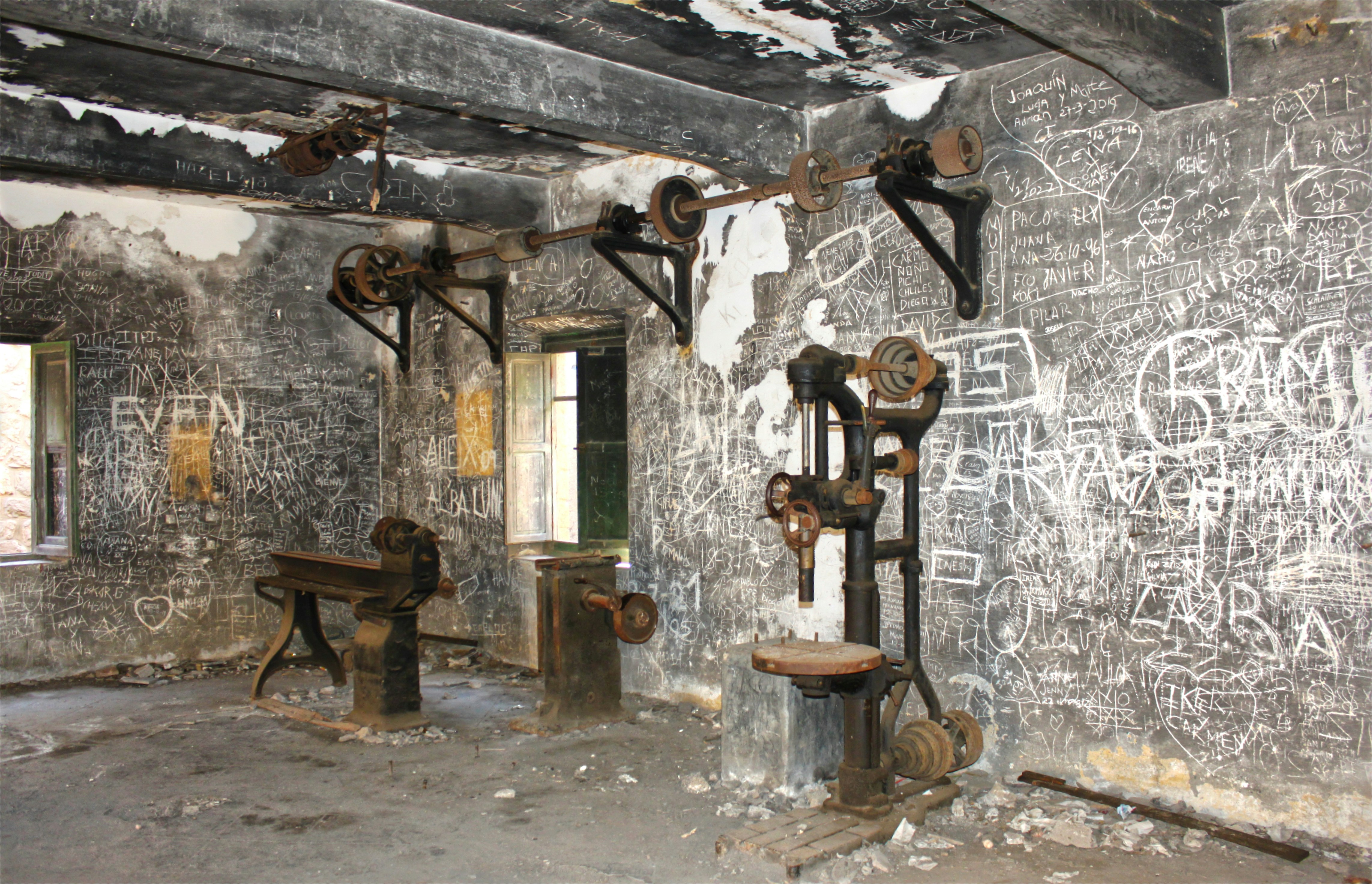 A room with graffiti on the walls and a bench