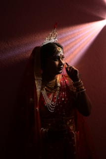 A woman standing in front of a red light