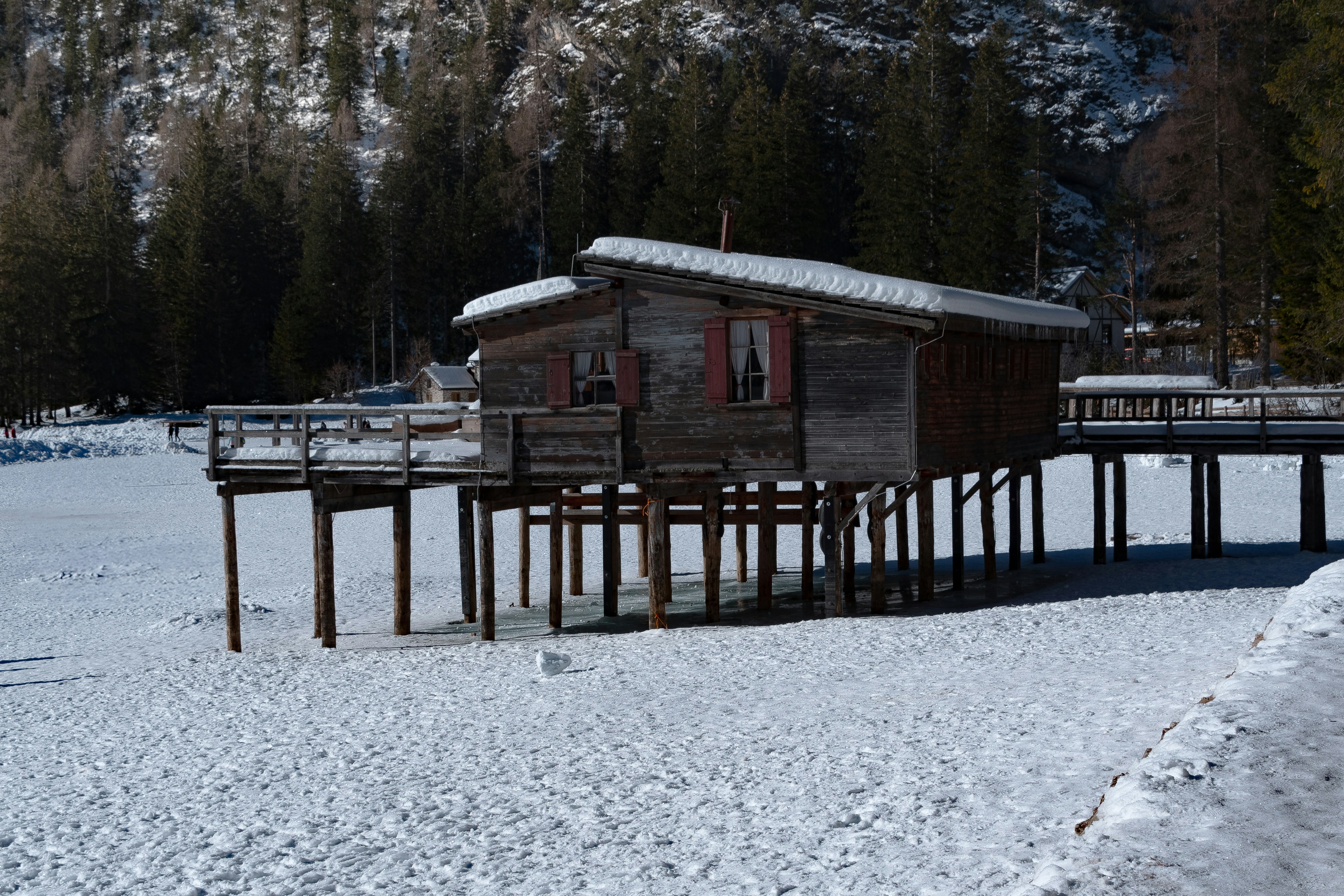 A snow covered field with a small cabin on it