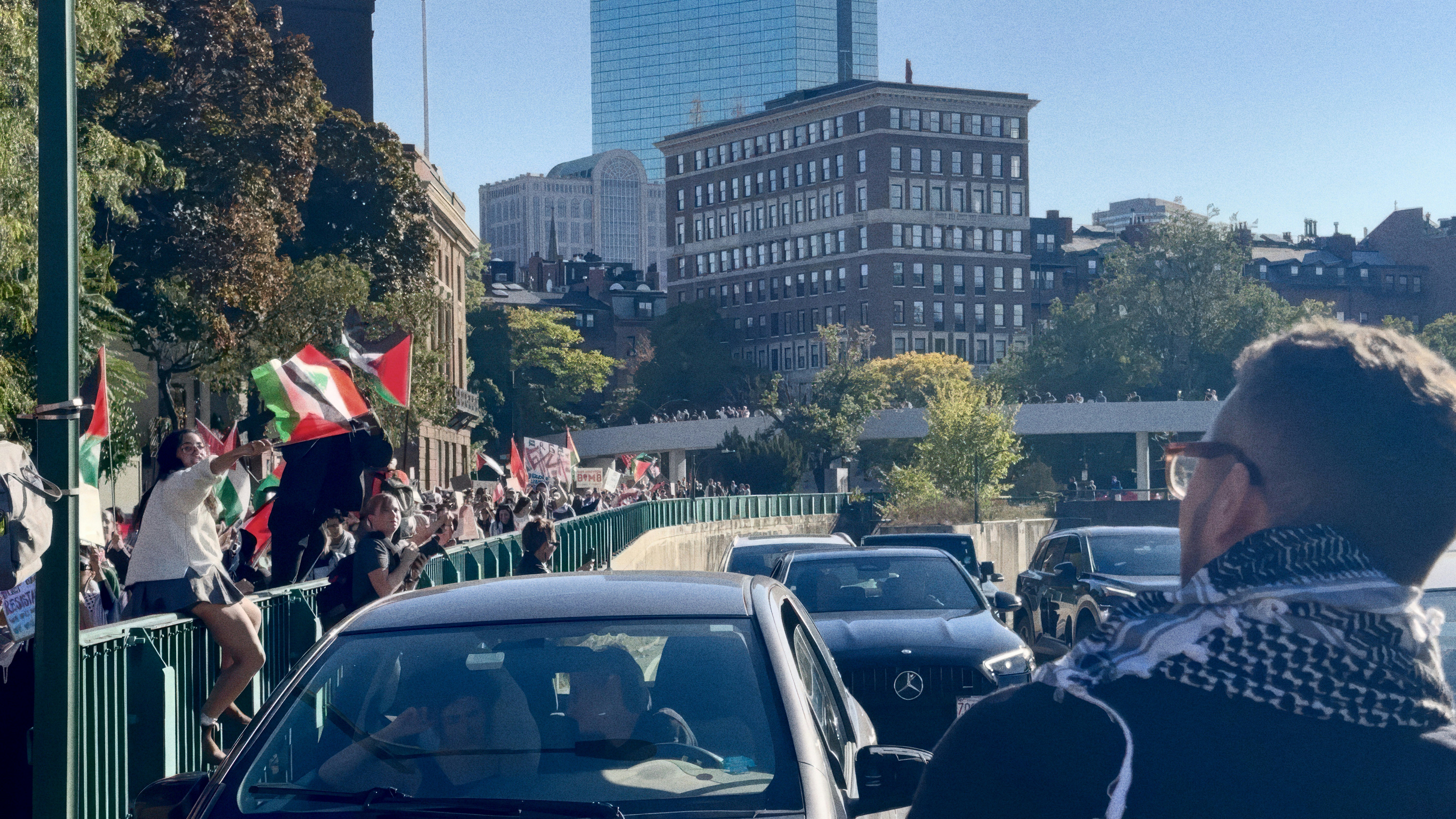 A crowd of people walking down a street next to tall buildings