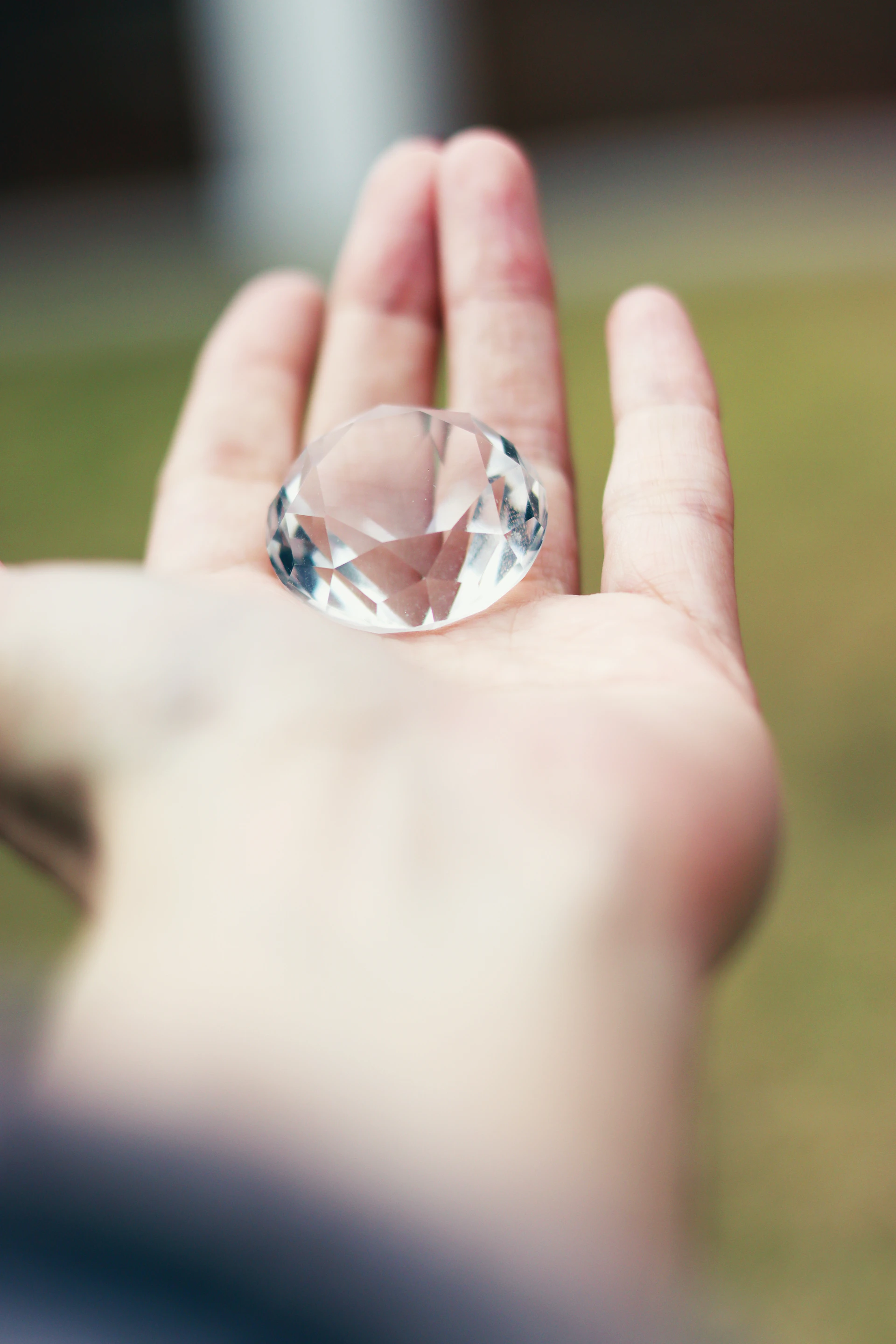A person holding a crystal ring in their hand