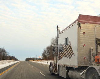 A semi truck driving down a snowy road