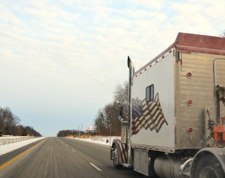 A semi truck driving down a snowy road
