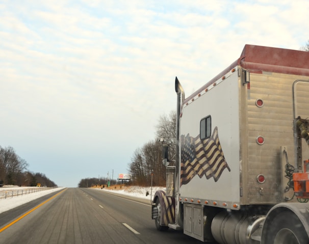 A semi truck driving down a snowy road