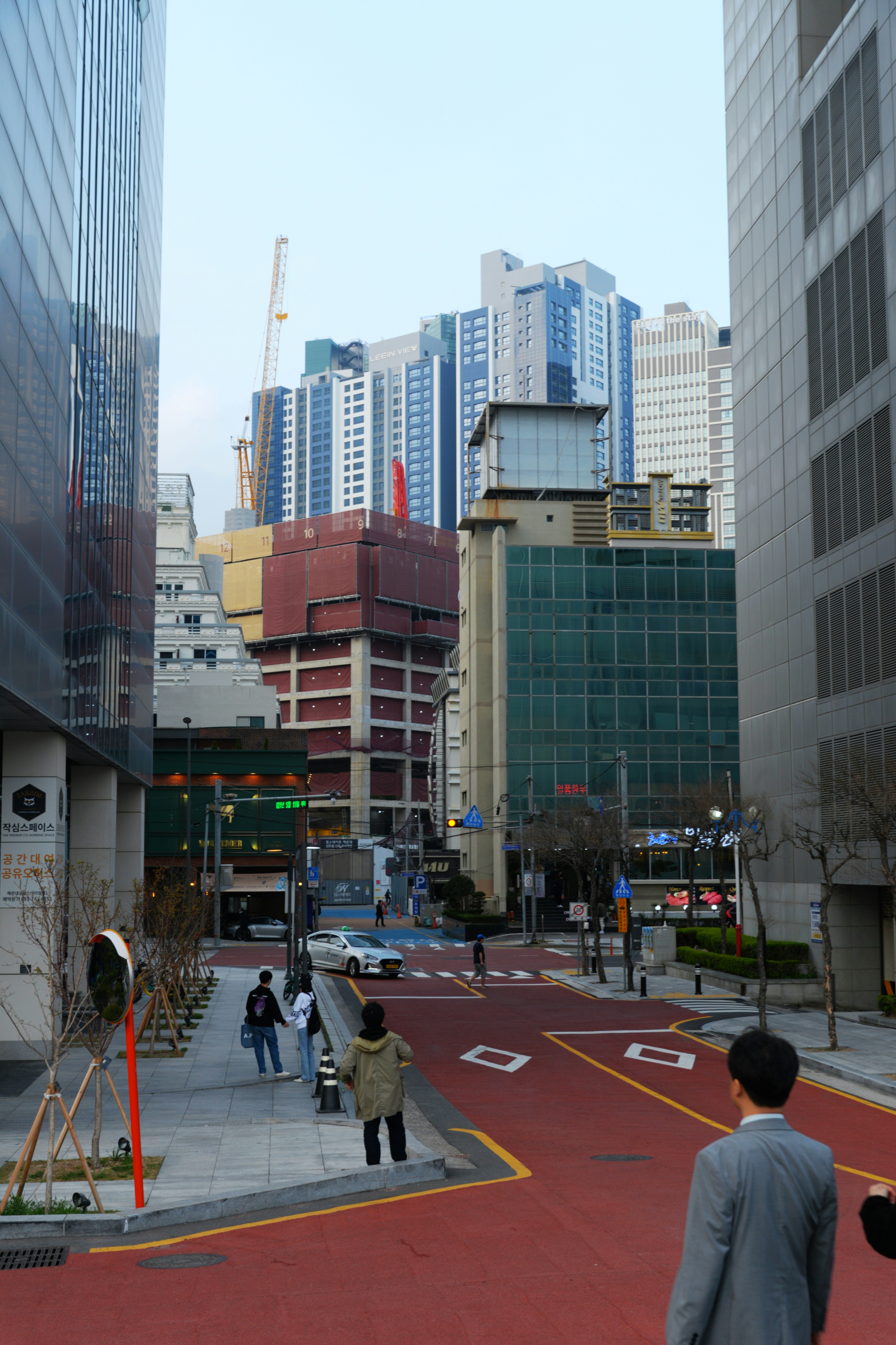 A man walking down a street next to tall buildings