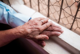 An older person holding the hand of a younger person