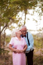 A man and woman standing next to each other in the woods