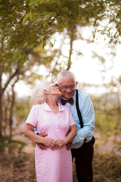 A man and woman standing next to each other in the woods