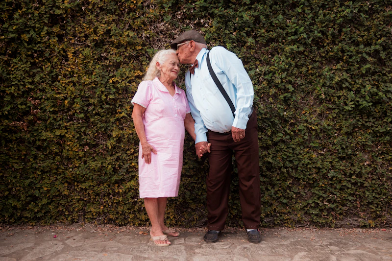 Couple standing in front of a hedge
