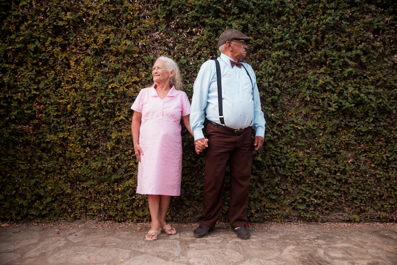 mature couple standing in front of a hedge