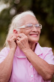 An older woman wearing glasses and a pink shirt