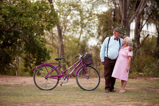 A man and a woman standing next to a purple bike
