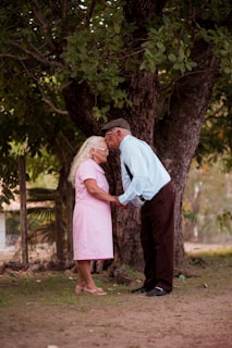 A man and a woman standing next to a tree