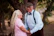 A man and woman standing next to each other near a tree