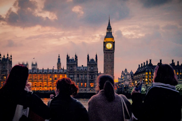 A group of people standing in front of a clock tower