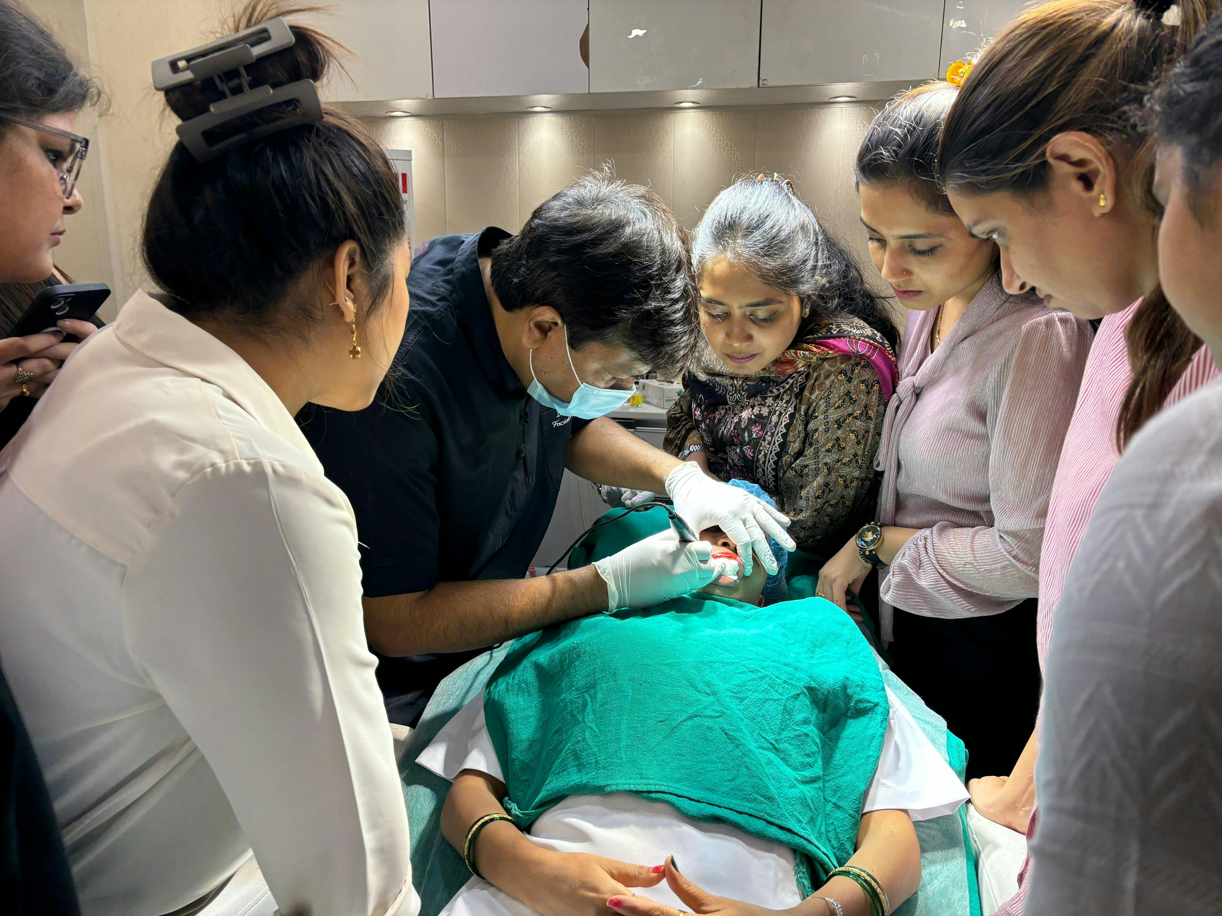 A group of people standing around a woman in a hospital bed