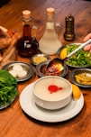 A wooden table topped with plates and bowls filled with food
