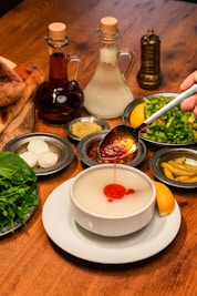 A wooden table topped with plates and bowls filled with food
