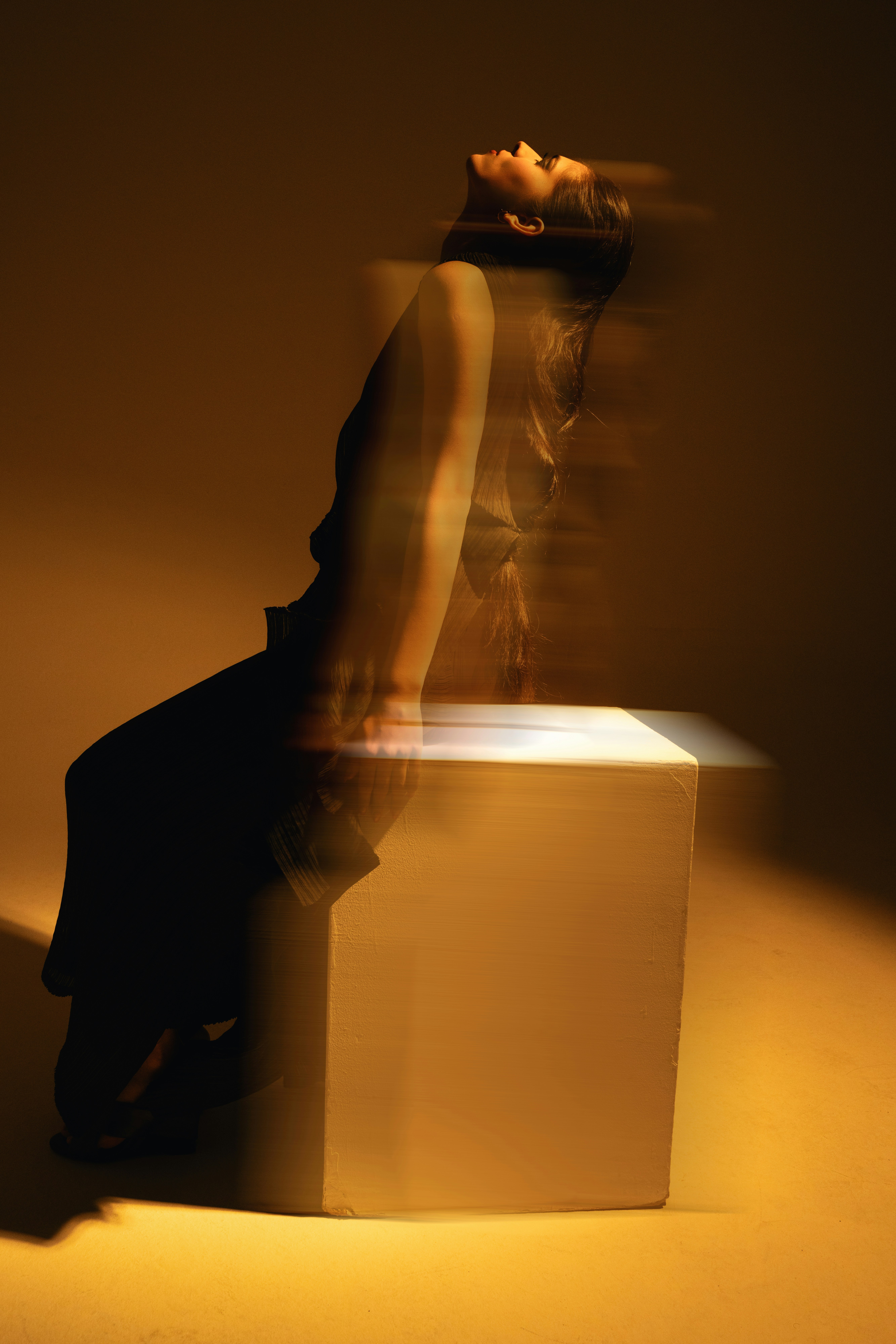 A woman sitting on top of a white box