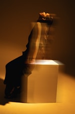 A woman sitting on top of a white box