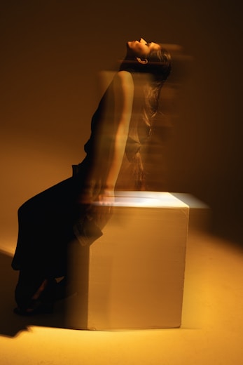 A woman sitting on top of a white box