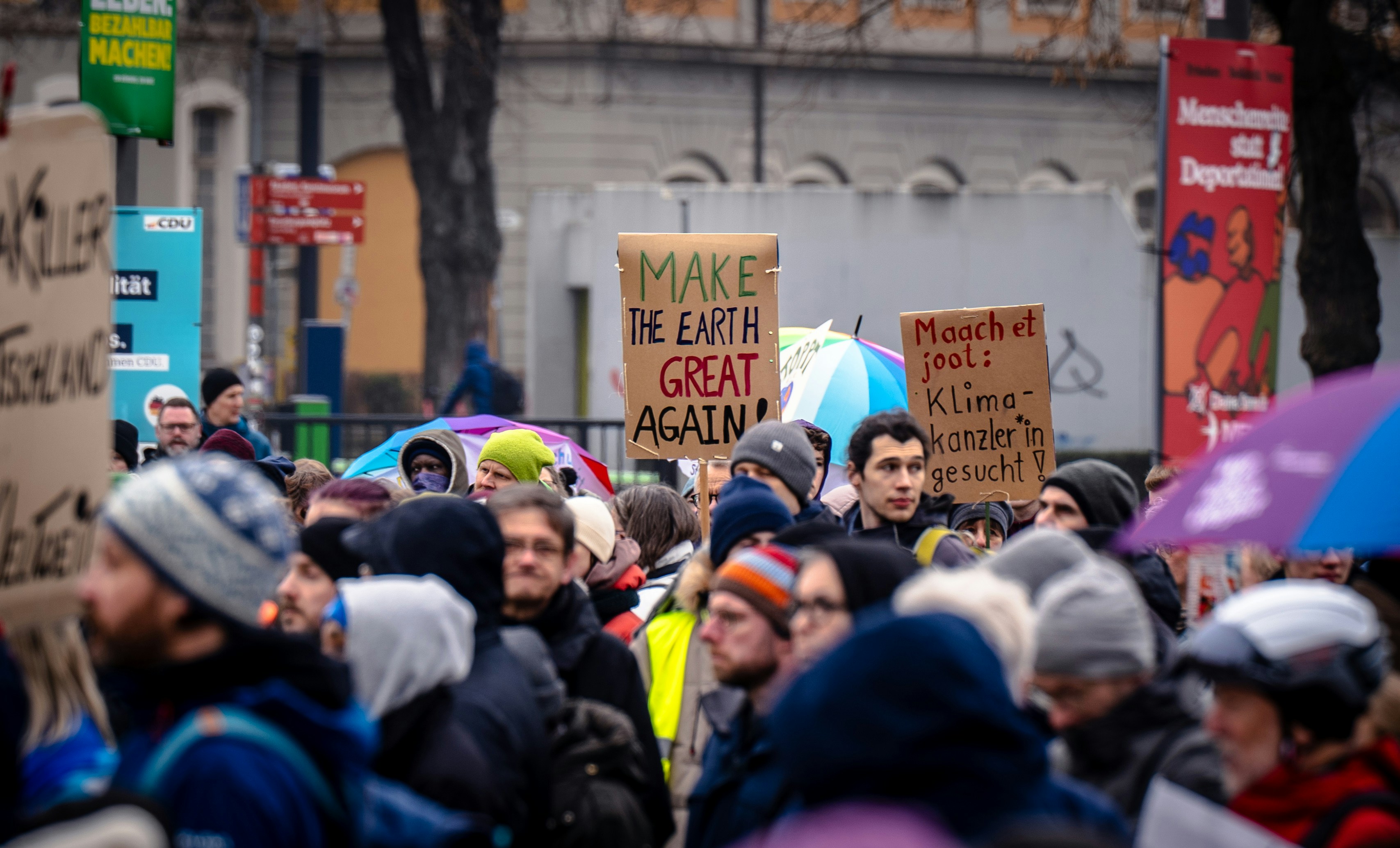 Eine Menschenmenge, die eine Straße entlang geht und Schilder hochhält
