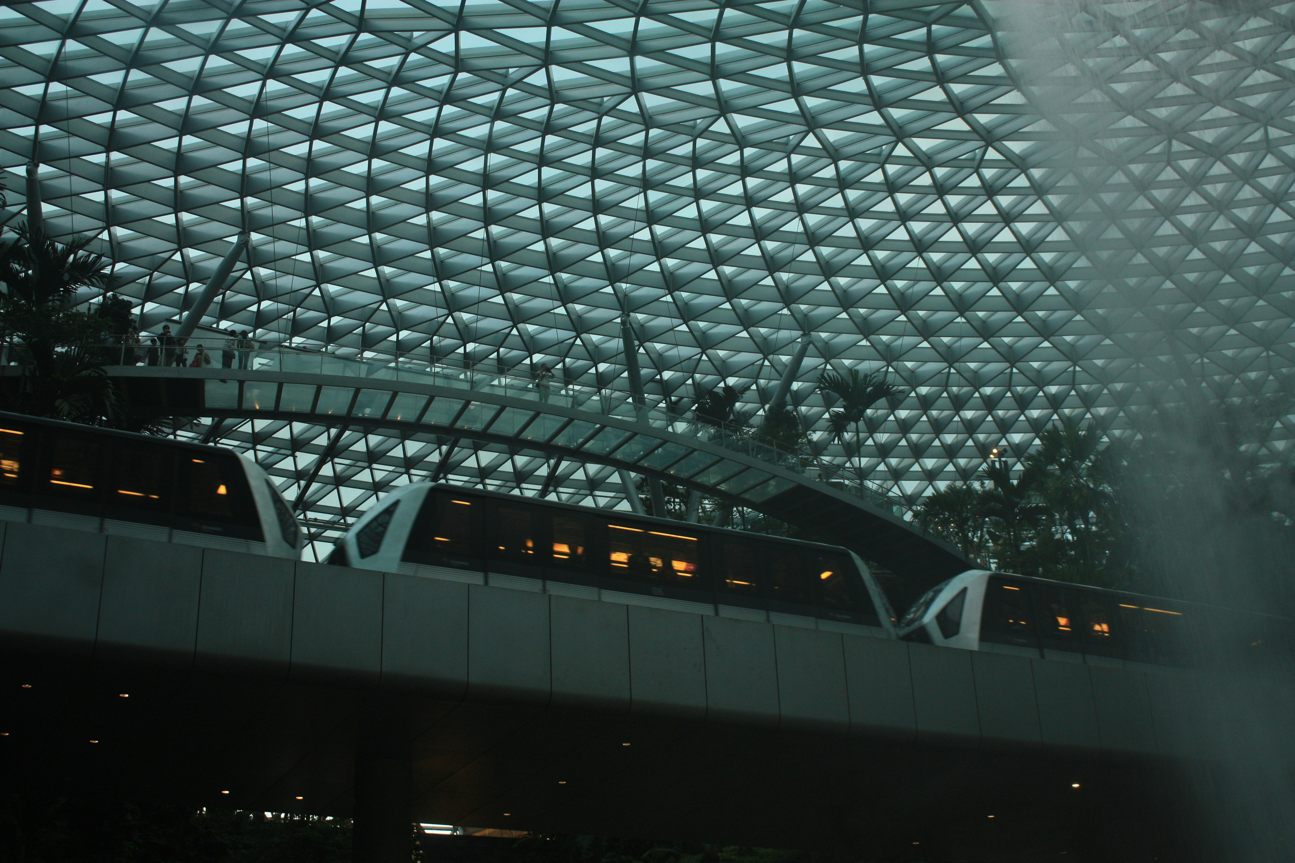 A train traveling through a train station next to a tall building photo ...