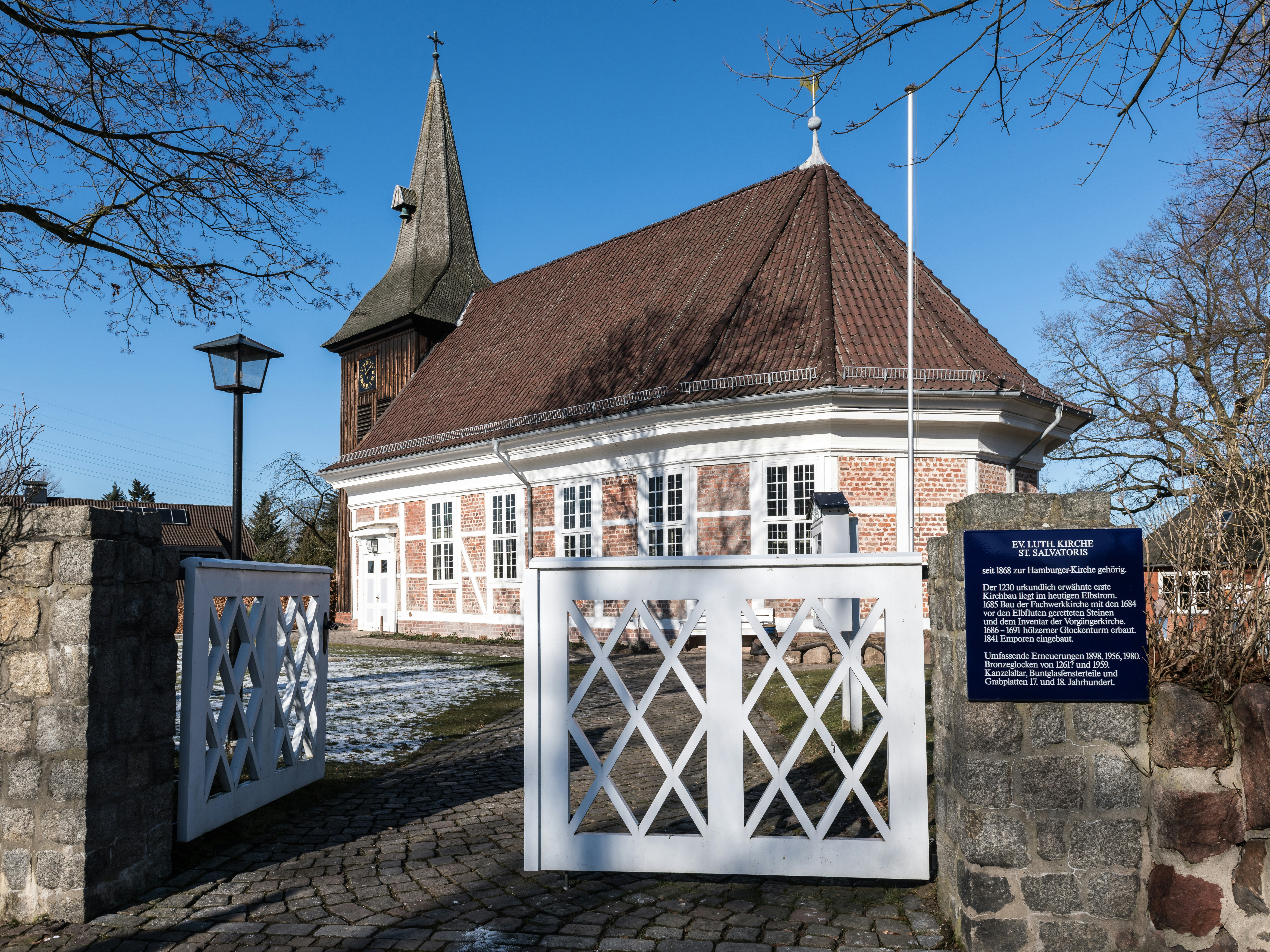 A brick building with a white gate in front of it