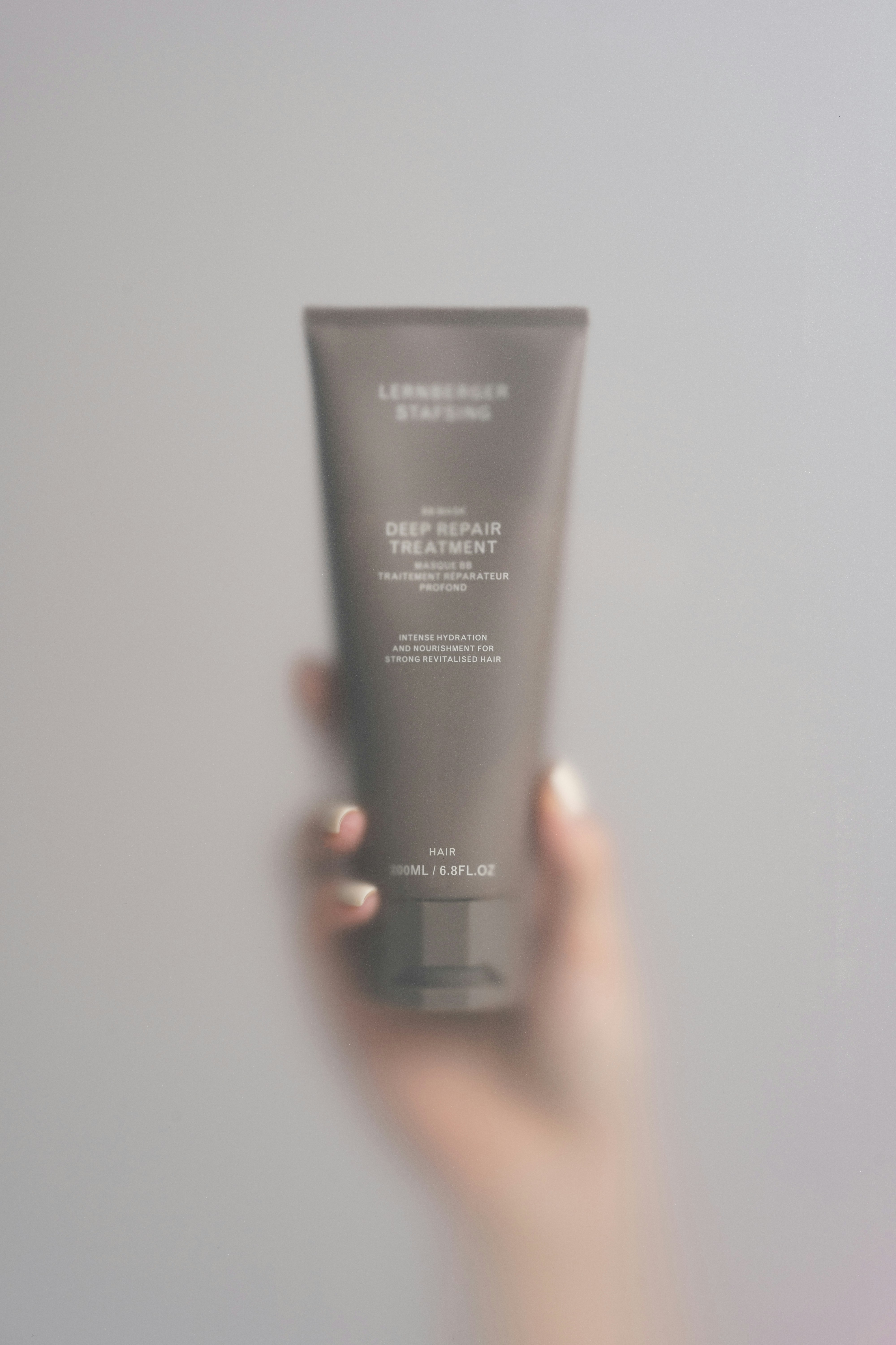 A person holding a tube of cream in their hand