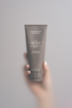 A person holding a tube of cream in their hand