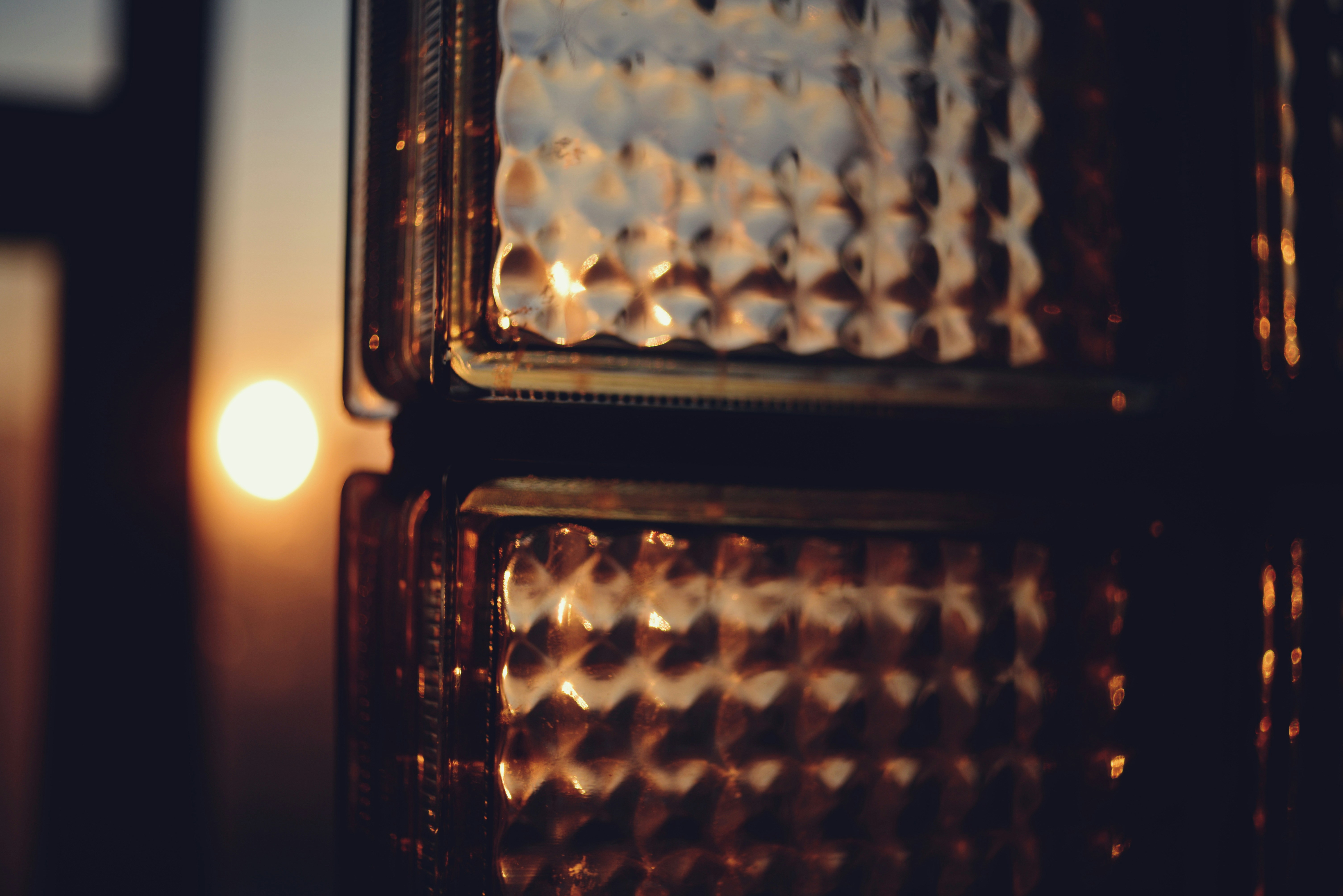 A close up of a street light with a candle in the background