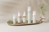 A tray with a bunch of bottles and a vase of flowers