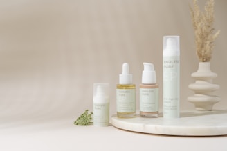 A white table with a bunch of bottles and a plant