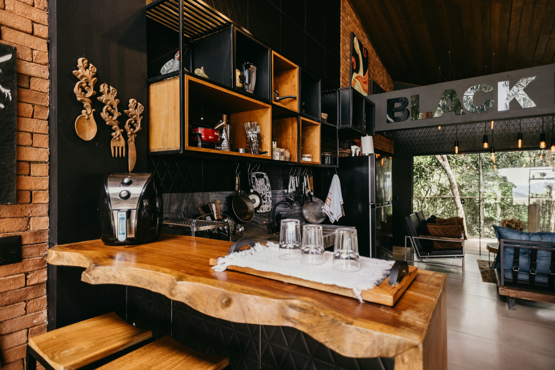 A kitchen with a wooden counter top and black walls