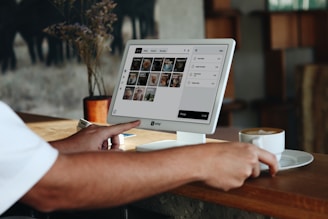 A man sitting at a table using a laptop computer