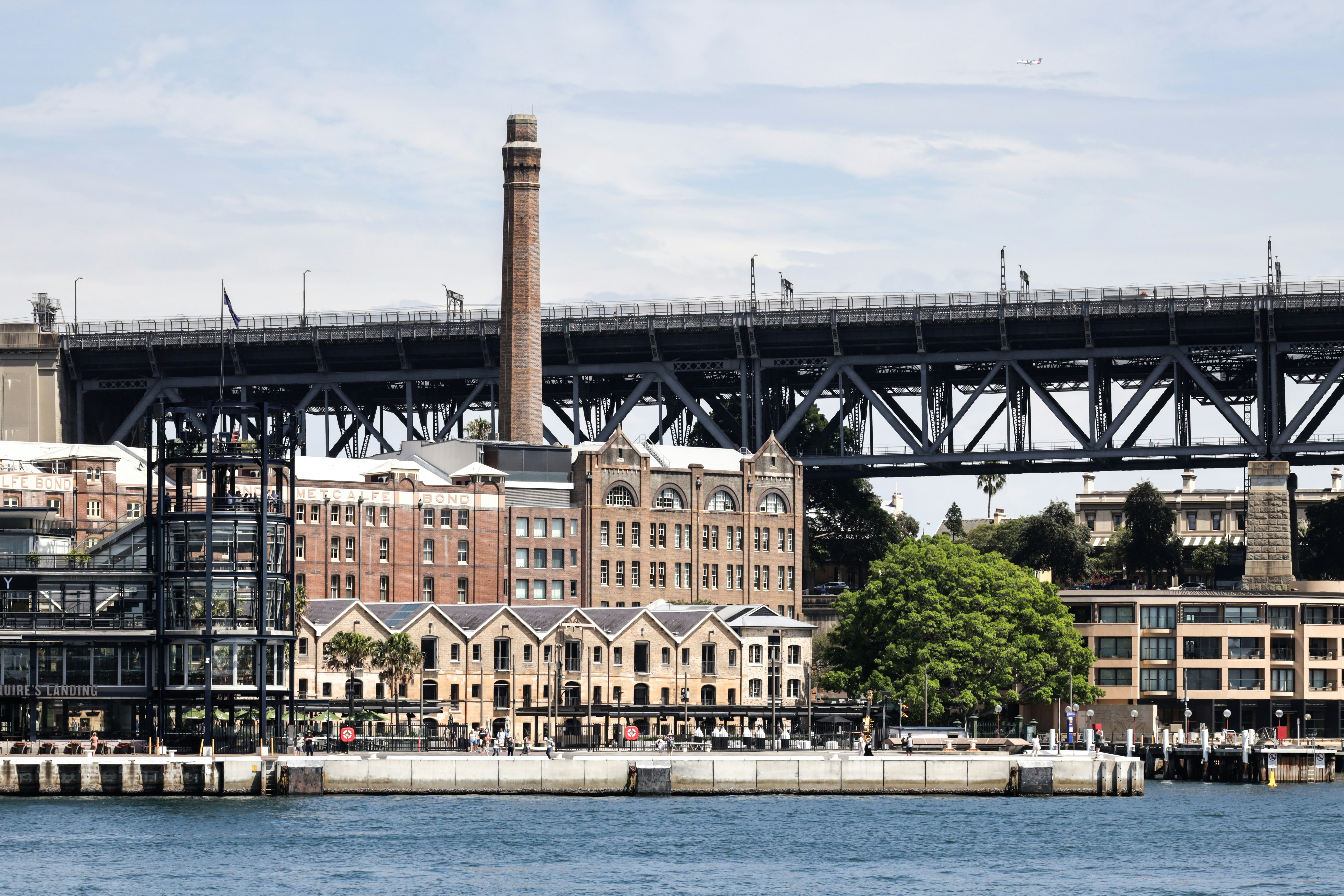 Uma ponte sobre um corpo de água com edifícios ao fundo