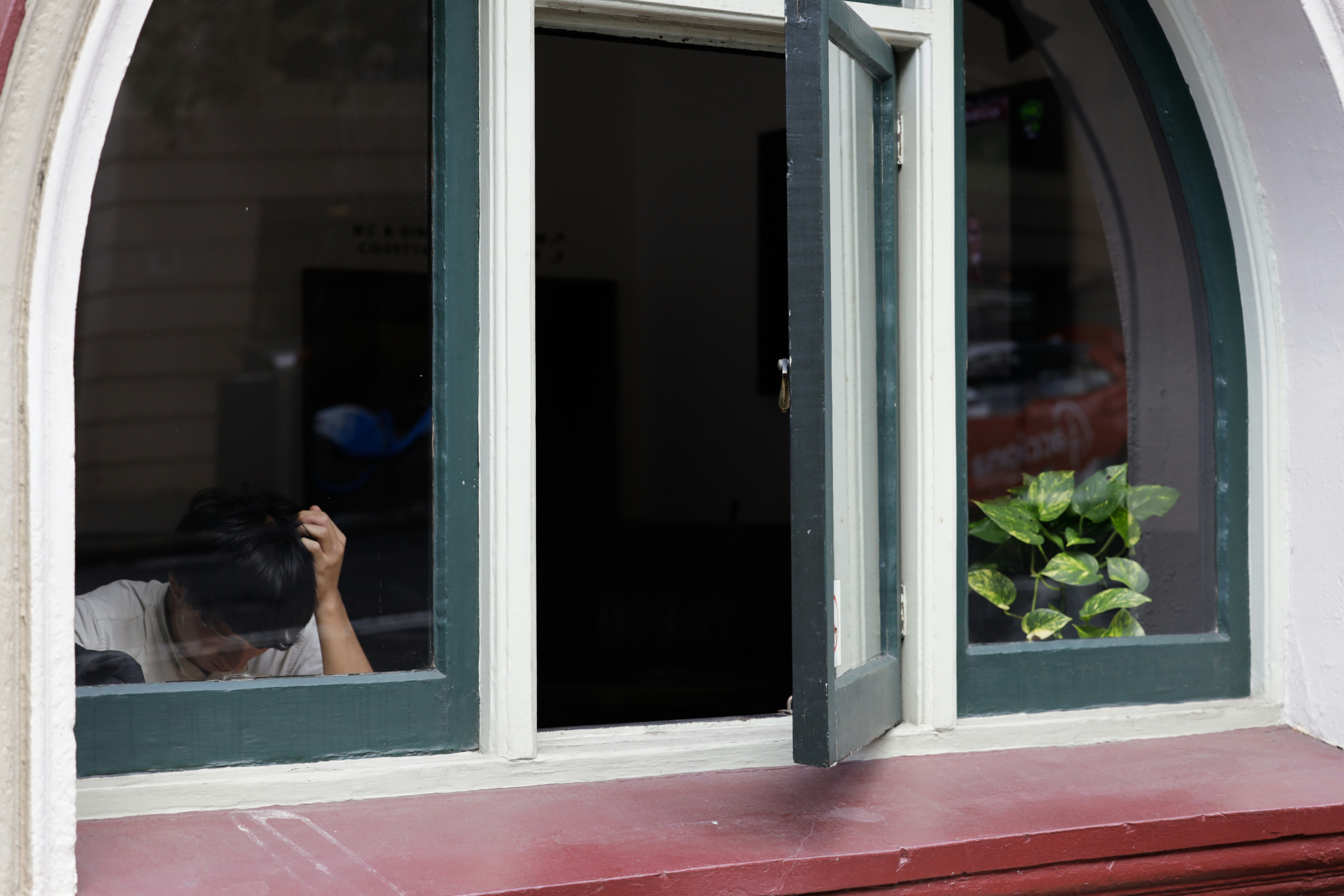 Uma mulher tirando uma foto de si mesma através de uma janela