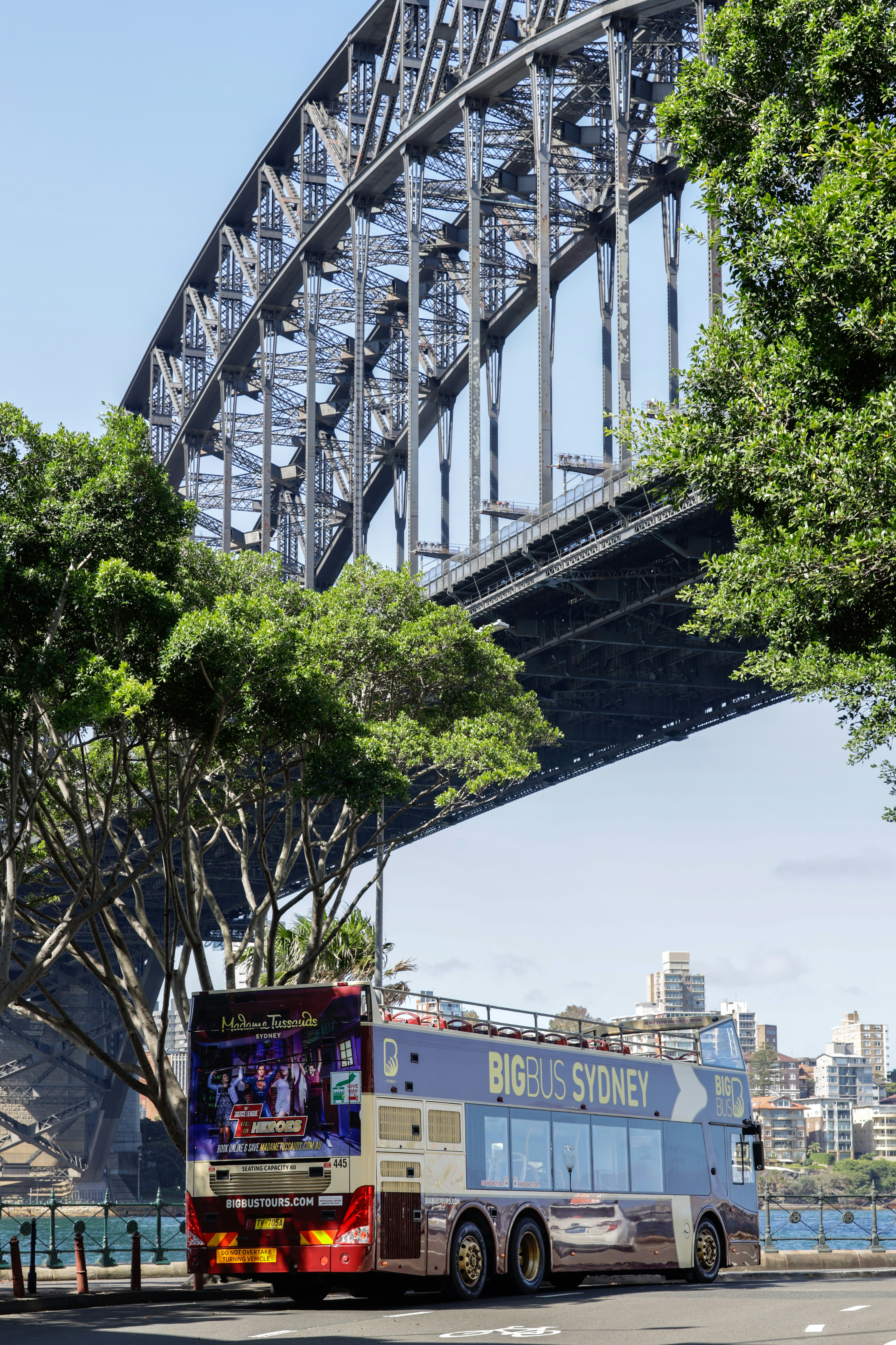 Um ônibus de dois andares passando por baixo de uma ponte