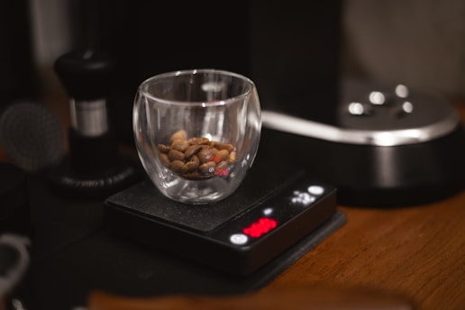 A glass with nuts in it sitting on a table