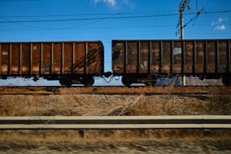 A train traveling down train tracks next to a field