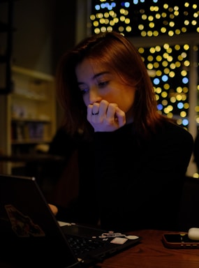 A woman sitting in front of a laptop computer