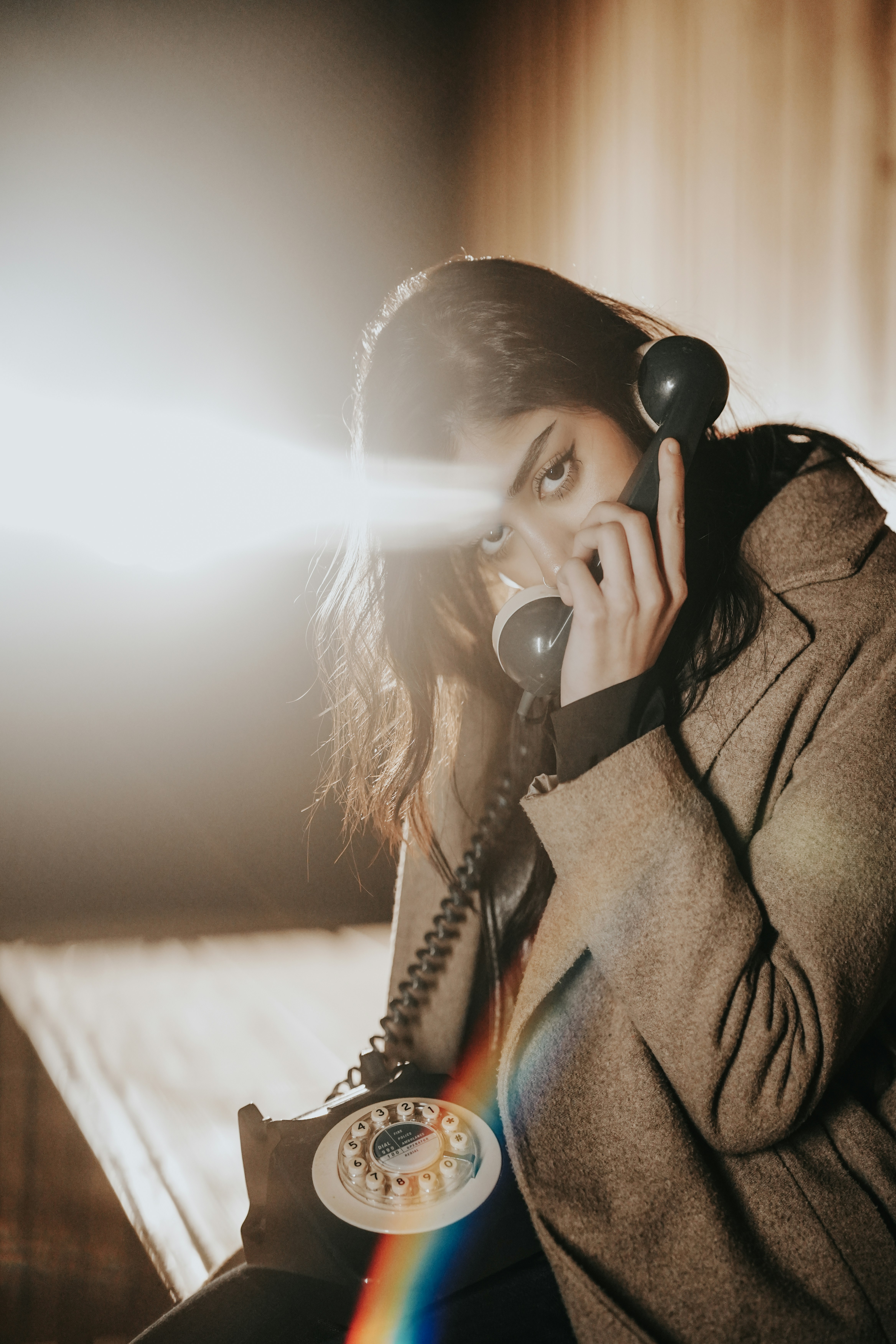Una mujer sentada en una cama hablando por teléfono
