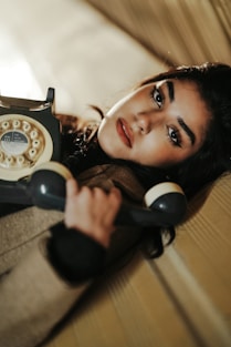 A woman laying on a couch holding a phone