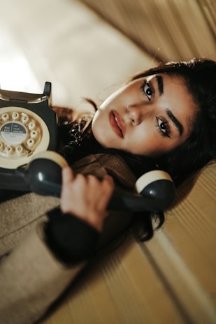 A woman laying on a couch holding a phone