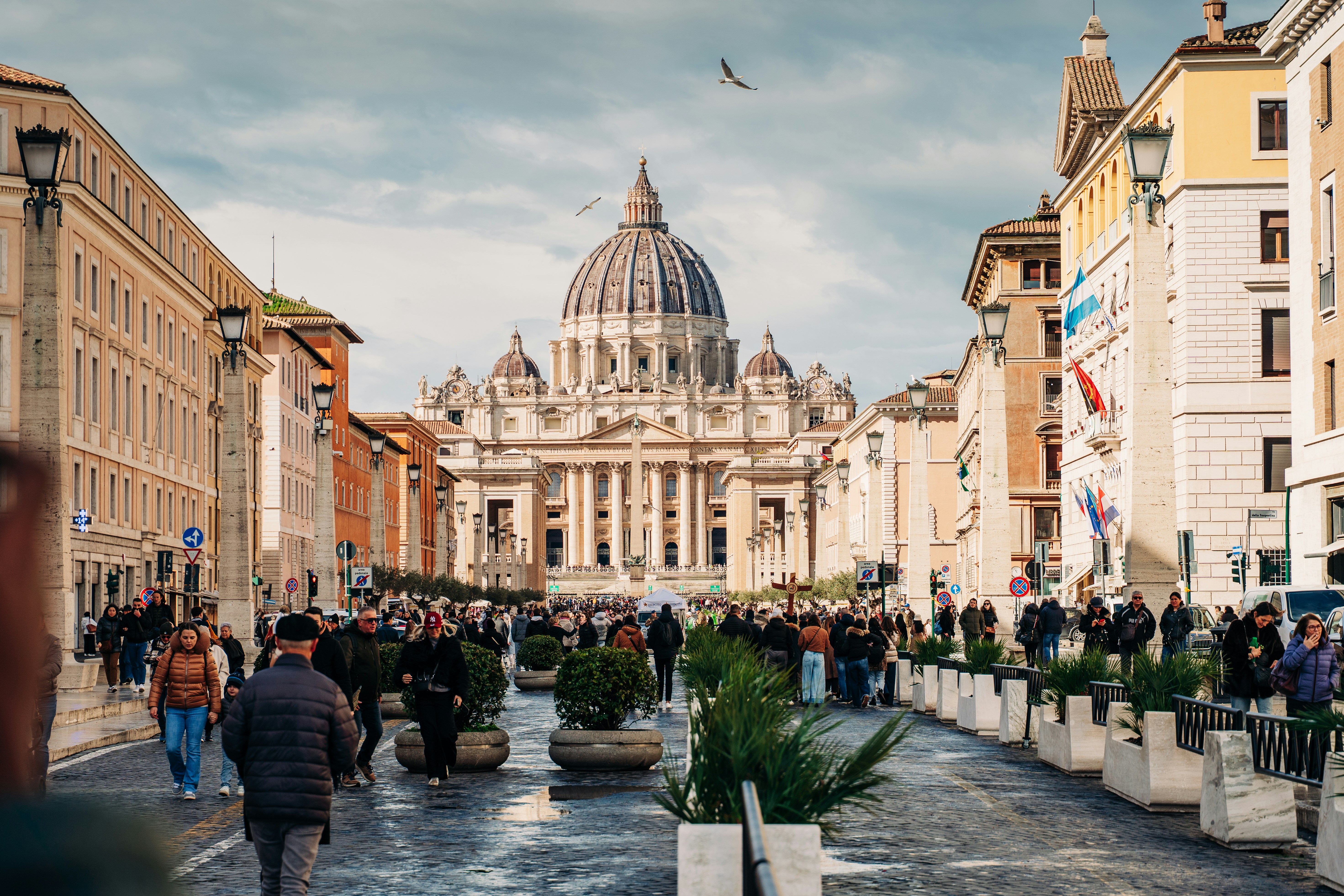 A group of people walking down a street next to tall buildings