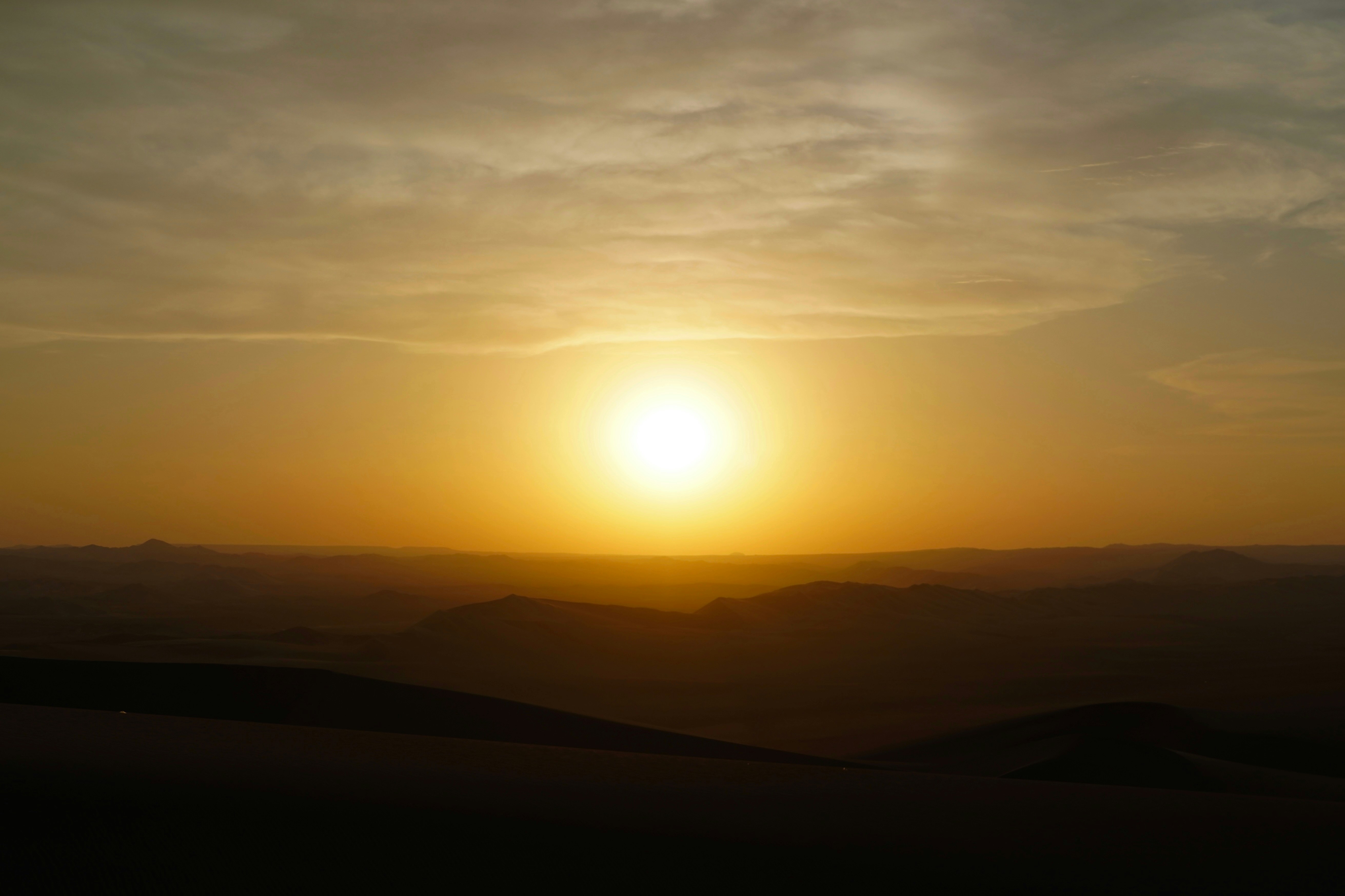 The sun is setting over a mountain range